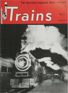 A magazine cover showing a train at night. The magazine's title appears in white letters on a red banner